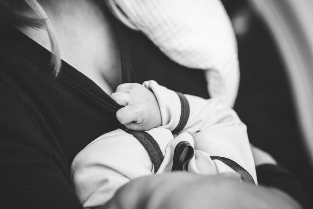 grayscale photo of woman carrying a baby